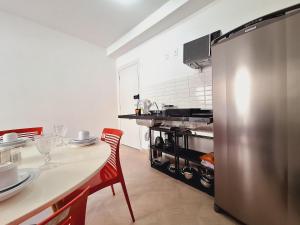 a kitchen with a table and a stainless steel refrigerator at LK Centro 2 in Belo Horizonte