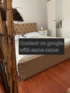 a bed in a room with words contact on google with same name at Iosia Premium Apartment in Oradea