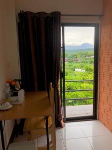 a room with a table and a window with a view at Sandee Place Mountain View Bed&Breakfast in Chom Thong