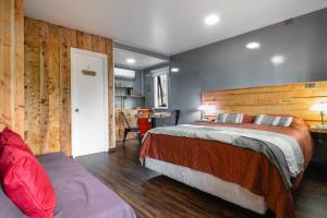 una camera da letto con un letto e una parete di legno di Pucón REC-Lodge Cabañas Las Bandurrias a Pucón