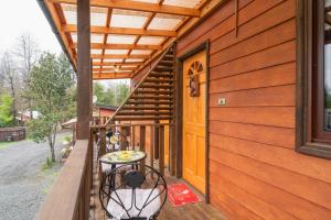 un portico con due panche e un tavolo sopra di Pucón REC-Lodge Cabañas Las Bandurrias a Pucón