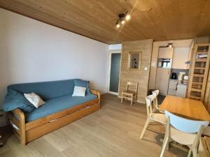 a living room with a blue couch and a table at Charmant 2 pièces 6 pers avec balcon sud, proche télé-siège et commerces à l'Alpe d'Huez - FR-1-405-3 in L'Alpe-d'Huez