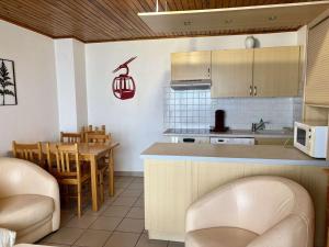 a kitchen and dining room with a table and chairs at Charmant 2 pièces avec balcon exposé Sud, proche télésiège et commerces, Vieil Alpe - FR-1-405-216 in LʼHuez +2 photos