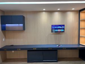 a room with a blue counter and a tv on the wall at LK Santo Agostinho 6 in Belo Horizonte