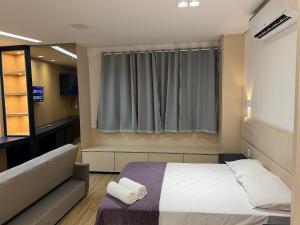 a hotel room with a bed and a window at LK Santo Agostinho 6 in Belo Horizonte
