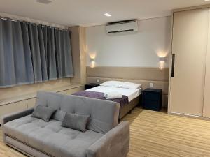 a living room with a bed and a couch at LK Santo Agostinho 6 in Belo Horizonte