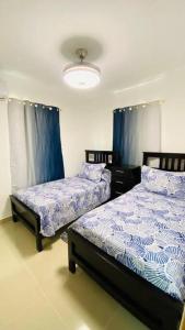 プンタ・カナにあるAmazing and cozy apt located in downtown of Punta Canaのベッドルーム(青と白のシーツ付)のベッド2台 +34枚の写真