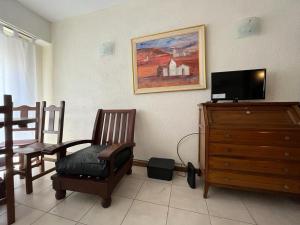 a living room with a tv and a wooden dresser at Depto Avenida Colón-Mar del Plata in Mar del Plata