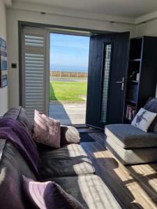 a living room with a couch and a sliding glass door at Seabreeze The Annexe in Blackpool