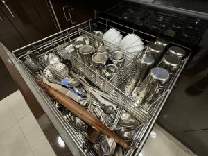 a dish rack filled with utensils in a kitchen at OSI Apartments Kurla West in Mumbai