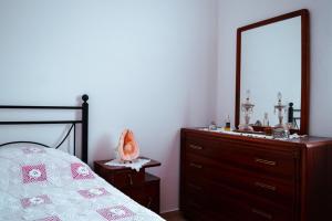 a bedroom with a bed and a dresser with a mirror at Tsikalario Holiday House in Tsikkalarión
