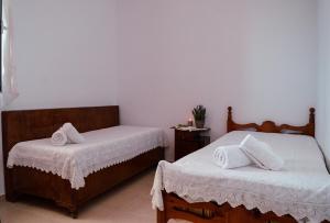 a bedroom with two beds with white linens at Tsikalario Holiday House in Tsikkalarión