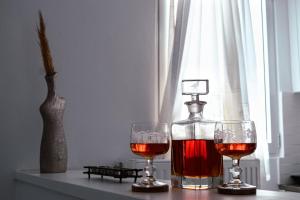 two glasses of wine and a bottle on a table at Tsikalario Holiday House in Tsikkalarión +16 photos