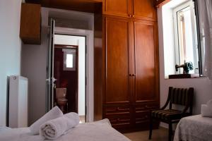 a bedroom with a bed and a cabinet and a chair at Tsikalario Holiday House in Tsikkalarión