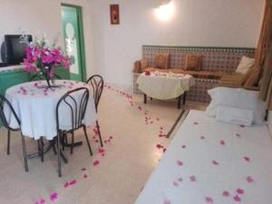 a room with a table and chairs with flowers on the floor at Residence Nour douz in Douz
