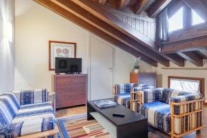sala de estar con 2 sofás y TV en Palazzo Brando - Living Apartments, en Treviso