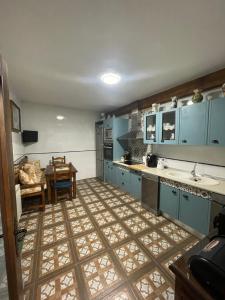 a kitchen with blue cabinets and a table in it at Casa rural los J esuses in Lillo