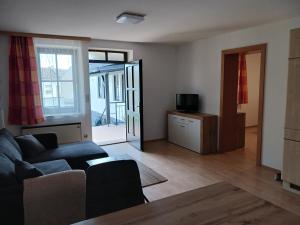 a living room with a couch and a tv at Ferienwohnungen & Weingut Kroiss Silvia in Illmitz