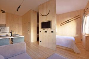 a bedroom with a bed and a kitchen with a tv at Cervino loft in Breuil-Cervinia