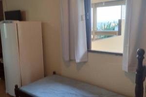 a room with a refrigerator next to a window at Suíte Iriri in Anchieta