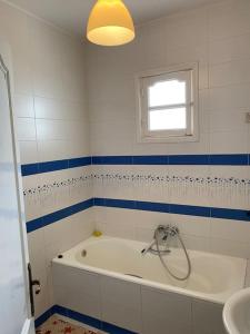 a bathroom with a tub and a window and a sink at Dar Sammoud A1 in Kelibia +11 photos
