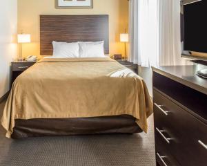 um quarto de hotel com uma cama e uma televisão de ecrã plano em MainStay Suites Pittsburgh Airport em Imperial