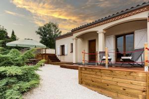 a house with a wooden deck and an umbrella at Proche d'Agen - Location de vacances 6 personnes avec piscine privée à la campagne in Colayrac-Saint-Cirq