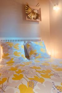 a bedroom with a bed with a yellow and white blanket at Proche d'Agen - Location de vacances 6 personnes avec piscine privée à la campagne in Colayrac-Saint-Cirq