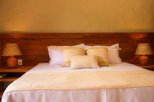 a bedroom with a large bed with two lamps at Pousada São Francisco DIAMANTE in São João Batista do Glória