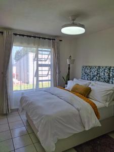 a bedroom with a large bed and a window at 18 Key Largo Ocean House of Uzurie in Kingsburgh