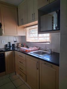 a small kitchen with a sink and a window at 18 Key Largo Ocean House of Uzurie in Kingsburgh