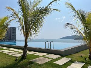 a swimming pool with two metal gates next to the water at Cozy JQ Level 25 Full Sea&Sunset View in Kota Kinabalu