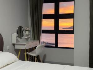 a bedroom with a bed and a desk and a window at Cozy JQ Level 25 Full Sea&Sunset View in Kota Kinabalu