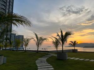 a walkway near the beach with palm trees at Cozy JQ Level 25 Full Sea&Sunset View in Kota Kinabalu +20 photos
