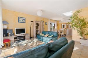a living room with a blue couch and a tv at Villa La Provençale - Piscine - Wifi - Clim in Saint-Mitre-les-Remparts