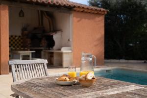 a table with a bowl of food and a glass of orange juice at Villa La Provençale - Piscine - Wifi - Clim in Saint-Mitre-les-Remparts