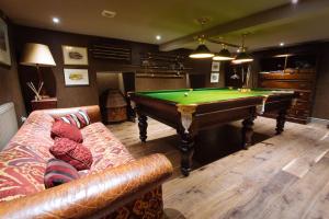 a living room with a pool table and a couch at Moscar Lodge, Peak District in Ughill