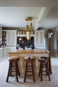 a kitchen with a large island with two stools at Moscar Lodge, Peak District in Ughill