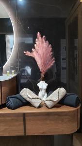 a table with a vase with a pink plant in it at Domaine du Saugé in La Riche