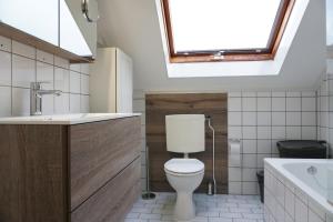 a bathroom with a toilet and a sink and a skylight at Kustverhuur, Vakantiepark Fort Soleil 23 in Breskens +9 photos