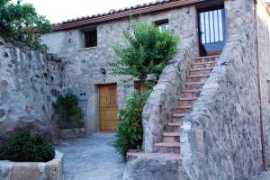 une maison en pierre avec des escaliers menant à une porte. dans l'établissement Apartamentos Rurales La Casa de Luis, à Santa Cruz de la Sierra