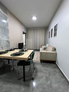 a living room with two tables and a couch at Loft Home Vila Bella in Cuiabá