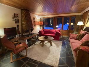 ein Wohnzimmer mit einem roten Sofa und einem Tisch in der Unterkunft Courchevel 1850 in Courchevel