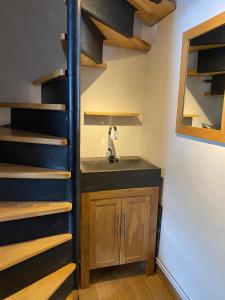 ein Raum mit Waschbecken und Wendeltreppe in der Unterkunft Courchevel 1850 in Courchevel