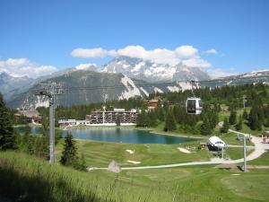 ein Golfplatz mit See und einem Resort in der Unterkunft Courchevel 1850 in Courchevel