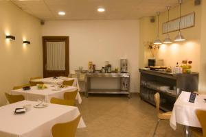 a dining room with two tables and a kitchen at Hotel Mayno in Pastrana
