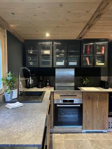 Una cocina con gabinetes de madera y electrodomésticos de acero inoxidable. en Mazot du Criou - Samoëns, en Samoëns