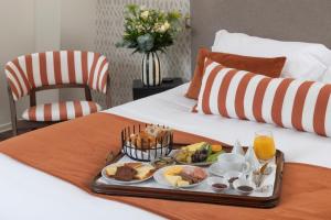 a tray of breakfast foods on a bed at Hôtel La Truffe Noire in Brive-la-Gaillarde