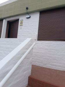 een witte garage met een deur en een gebouw bij Santa Ana Alojamiento in Puerto Madryn +1 foto