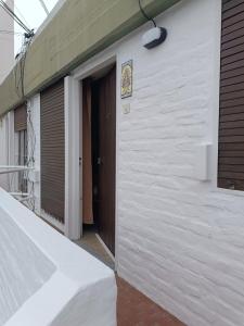 een wit gebouw met een deur en een straatlicht bij Santa Ana Alojamiento in Puerto Madryn